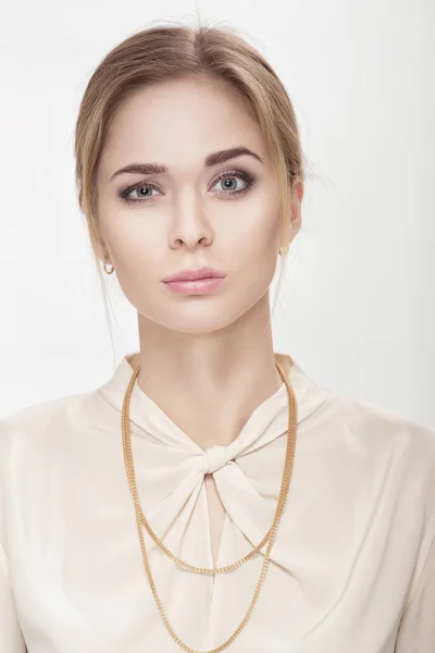 Portrait of beautiful young upset woman in white shirt smiling and looking at camera — Stock Photo, Image