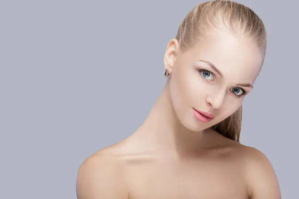 Portrét krásná mladá blondýnka s modrýma očima na šedém pozadí. dívka s čistou pokožku — Stock fotografie