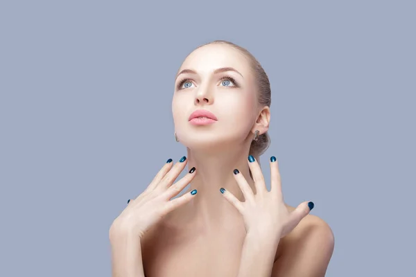 Mooie vrouw blond toont haar perfecte manicure op grijze achtergrond — Stockfoto