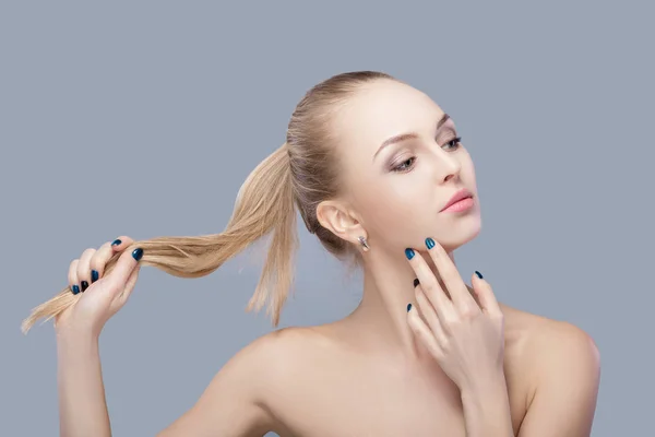 Retrato de una hermosa joven rubia con ojos azules sobre fondo gris. chica con la piel limpia —  Fotos de Stock