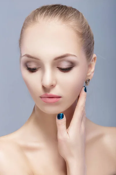 Retrato de una hermosa joven rubia con ojos azules sobre fondo gris. chica con la piel limpia —  Fotos de Stock