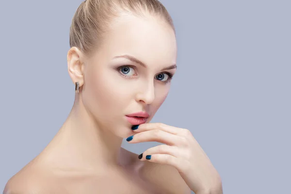 Retrato de una hermosa joven rubia con ojos azules sobre fondo gris. chica con la piel limpia —  Fotos de Stock