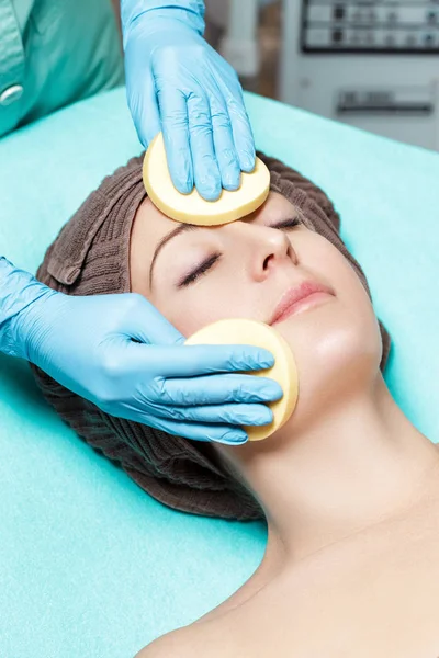 Medico estetista purifica la pelle della donna con spugna. trattamento cosmetologico viso di cura della pelle. Procedure termali — Foto Stock