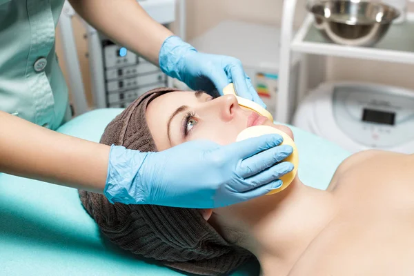 Доктор косметолог очищает кожу женщины губкой. косметологическое лечение кожи лица. СПА процедуры — стоковое фото