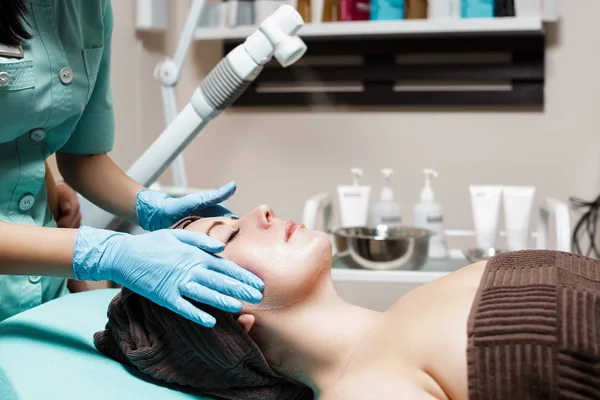 Massage facial anti-âge. cosmétologue faire massage pour jeune femme au salon Spa . — Photo
