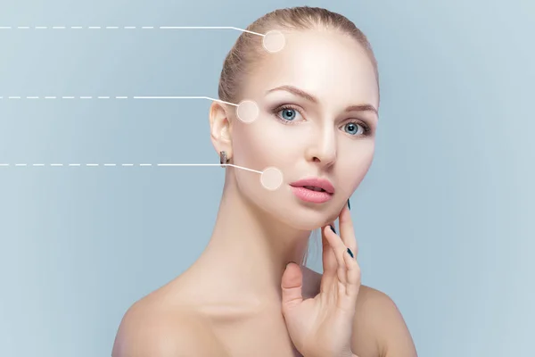 Spa portrait of young and natural woman with dotted arrows on face on blue background. Medicine and skin care — Stock Photo, Image