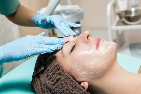 Masaje facial antienvejecimiento. cosmetólogo haciendo masaje para mujer joven en el salón de Spa . — Foto de Stock