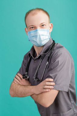 Maskeli kameraya mavi arka plan üzerinde seyir stetoskop ile erkek doktor