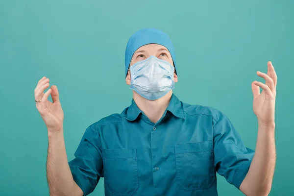 Mannelijke chirurg in masker camera kijken op blauwe achtergrond, close-up — Stockfoto