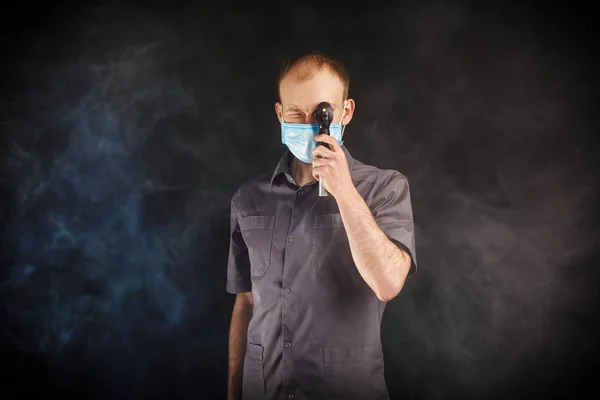 Jonge dokter in een masker in rook — Stockfoto