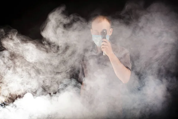 Doutor jovem em uma máscara na fumaça — Fotografia de Stock