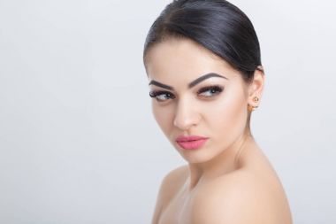 Açık gri arka plan üzerinde çekici genç esmer kadın portresi. Temiz Cilt kızla