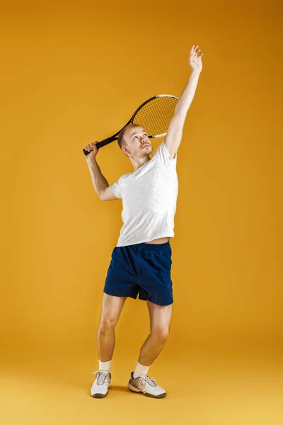 黄色の背景にテニスをする若いテニス選手 — ストック写真