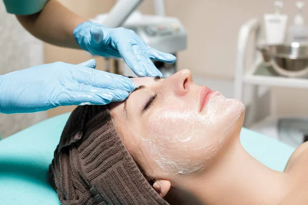 Masaje facial antienvejecimiento. cosmetólogo haciendo masaje para mujer joven en el salón de Spa . — Foto de Stock