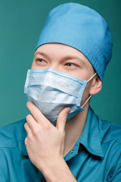 Mannelijke chirurg in masker op blauwe achtergrond, close-up — Stockfoto