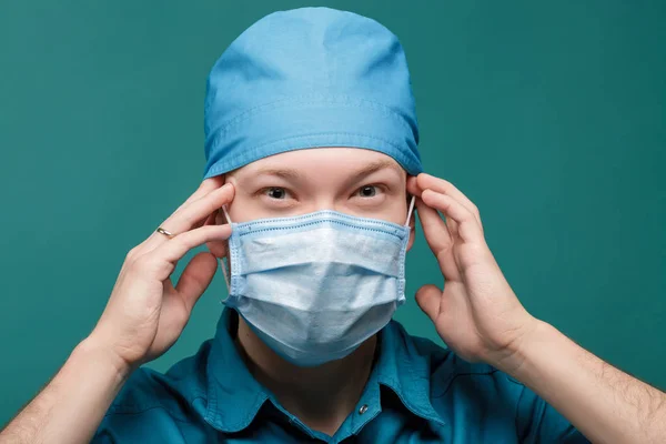 Trött manliga kirurg i masken på blå bakgrund, närbild — Stockfoto