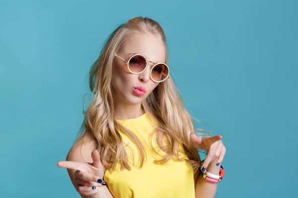 Retrato de hermosa mujer rubia en gafas de sol y camisa amarilla sobre fondo azul. Verano despreocupado . —  Fotos de Stock