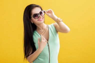 Sarı zemin üzerine Yeşil mayo çekici genç kadın. Yaz seksi kız turkuaz gömlek ve güneş gözlüğü