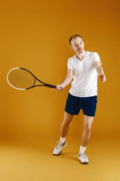 Jeune joueur de tennis joue au tennis sur fond jaune — Photo