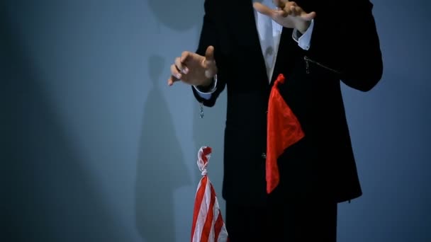 Goochelaar toont truc met vliegende rode servet op zwarte achtergrond. — Stockvideo