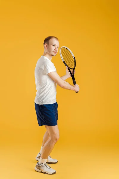 Jeune joueur de tennis joue au tennis sur fond jaune — Photo