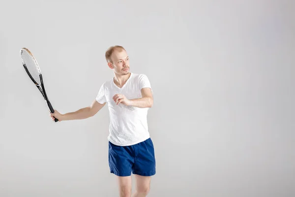 灰色の背景にテニスをする若いテニス選手 — ストック写真