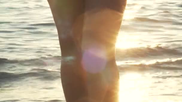 Belos pés femininos bronzeados contra o mar ao pôr do sol — Vídeo de Stock