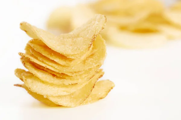 Хрустящие картофельные чипсы на белом фоне крупным планом — стоковое фото