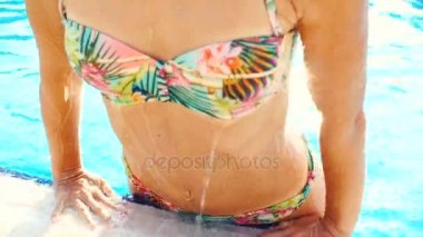 Güneşli yaz gününde havuzda bikinili genç esmer kadın