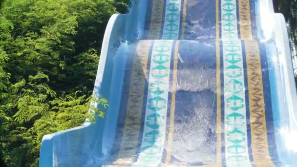 Lyckliga paret glider ner vattenrutschbana leende i solig sommar. Water Park. — Stockvideo