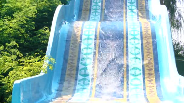 Lyckliga paret glider ner vattenrutschbana leende i solig sommar. Water Park. — Stockvideo