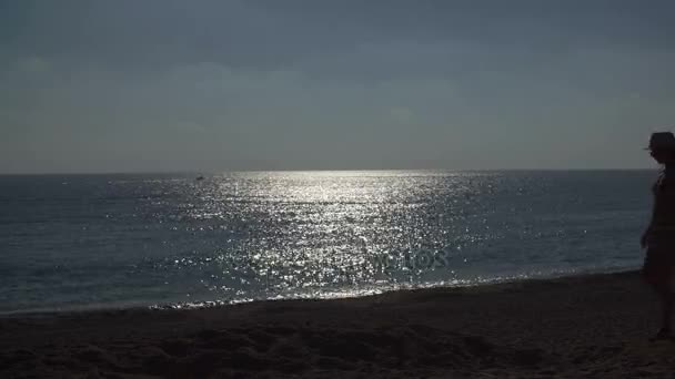 Silhouet van jonge vrouw loopt op strand op zee achtergrond — Stockvideo