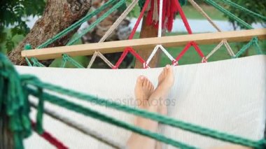 Hamakta açık havada sallanan kadın bacakları