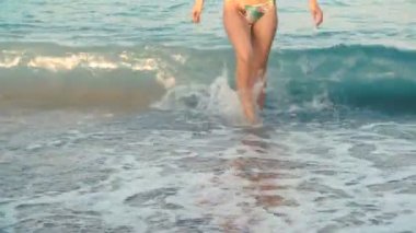 Bayan güzel tabaklanmış bacaklarını Plajı'nda sudan. Kız deniz kenarında yürüyüş