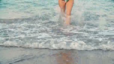 Bayan güzel tabaklanmış bacaklarını Plajı'nda sudan. Kız deniz kenarında yürüyüş