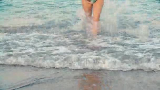 Жіночі красиві засмаглі ноги з води на пляжі. Дівчина, що йде морем — стокове відео