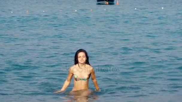 Femmes belles jambes bronzées hors de l'eau à la plage. Fille marche par la mer — Video