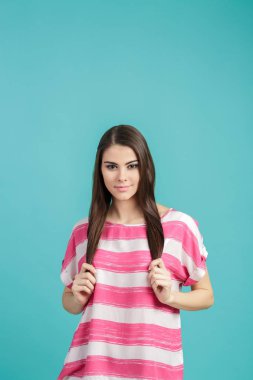 mavi arka plan üzerinde Pembe gömlekli uzun saçlı güzel genç gülümseyen kadın.