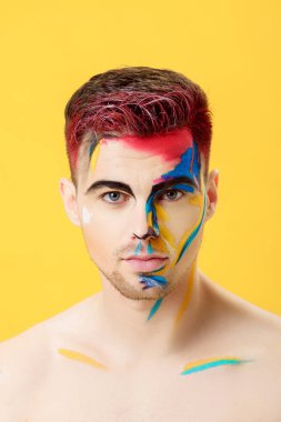 sarı arka plan üzerinde renkli yüz boyama ile genç adam portresi. Profesyonel makyaj moda. fantezi sanat makyaj