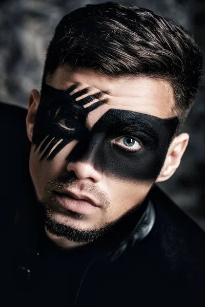 Maquillaje de arte de fantasía. Hombre joven con máscara pintada de negro en la cara Close up Portrait. Maquillaje de moda profesional . — Foto de Stock