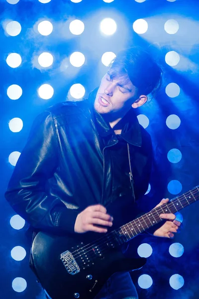 젊은 록 음악가 전기 기타 연주와 노래입니다. 스포트 라이트의 배경에 록 스타 — 스톡 사진
