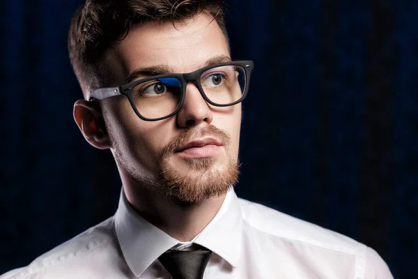 Retrato de joven guapo con gafas y camisa blanca sobre fondo oscuro — Foto de Stock