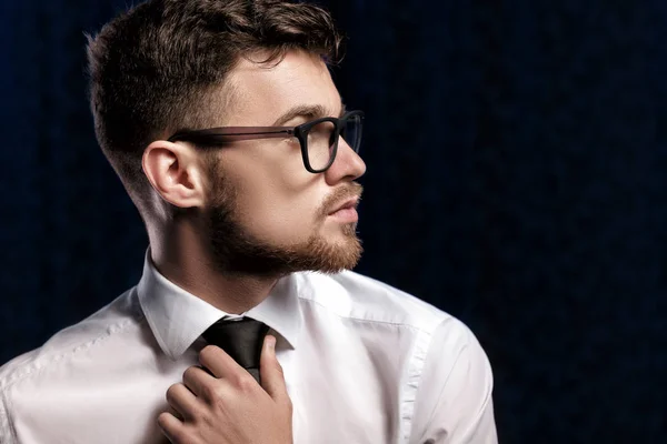 Profil de beau jeune homme avec des lunettes et chemise blanche sur fond sombre — Photo