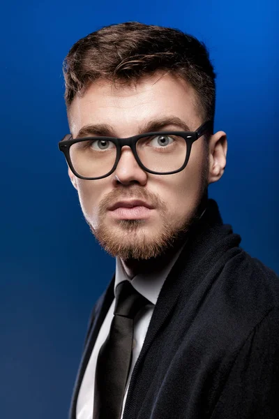 Retrato de joven guapo con gafas y camisa blanca sobre fondo azul — Foto de Stock