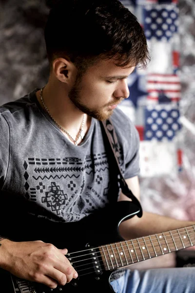 어두운 배경에서 전기 기타를 연주 젊은 잘생긴 음악가 — 스톡 사진