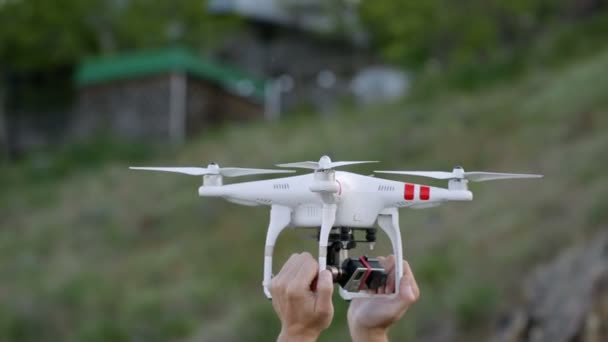 Les mains des hommes tiennent drone. l'exploitant étalonne le quadrocopter avant le vol — Video