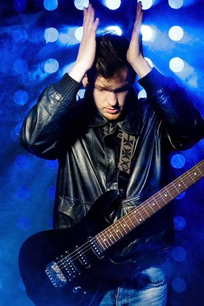 매력적인 젊은 록 음악가 전기 기타 연주와 노래. 스포트 라이트의 배경에 록 스타 — 스톡 사진