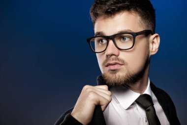 Yakışıklı genç adam arka plan mavi gözlük ve beyaz forması ile portresi