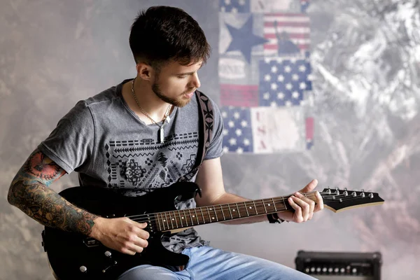 어두운 배경에서 전기 기타를 연주 젊은 잘생긴 음악가 — 스톡 사진