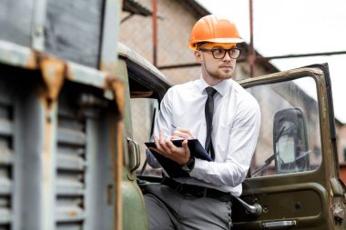 Mühendis Oluşturucu bir kask içinde çizimler inşaat alanında tutar.